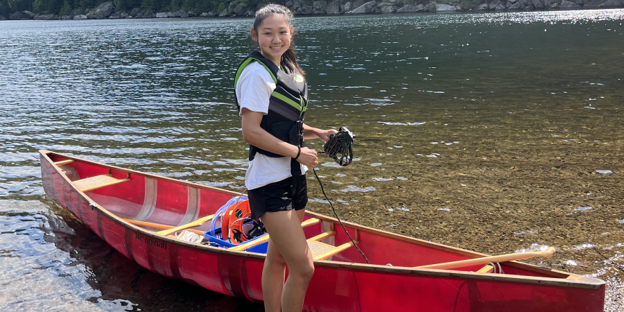 woman with red boat on a lake shore