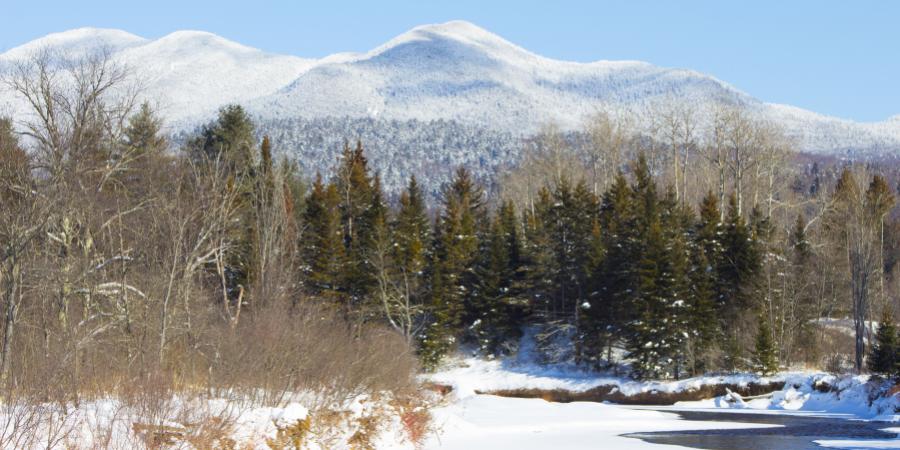 frozen river with snowy mountains in the background